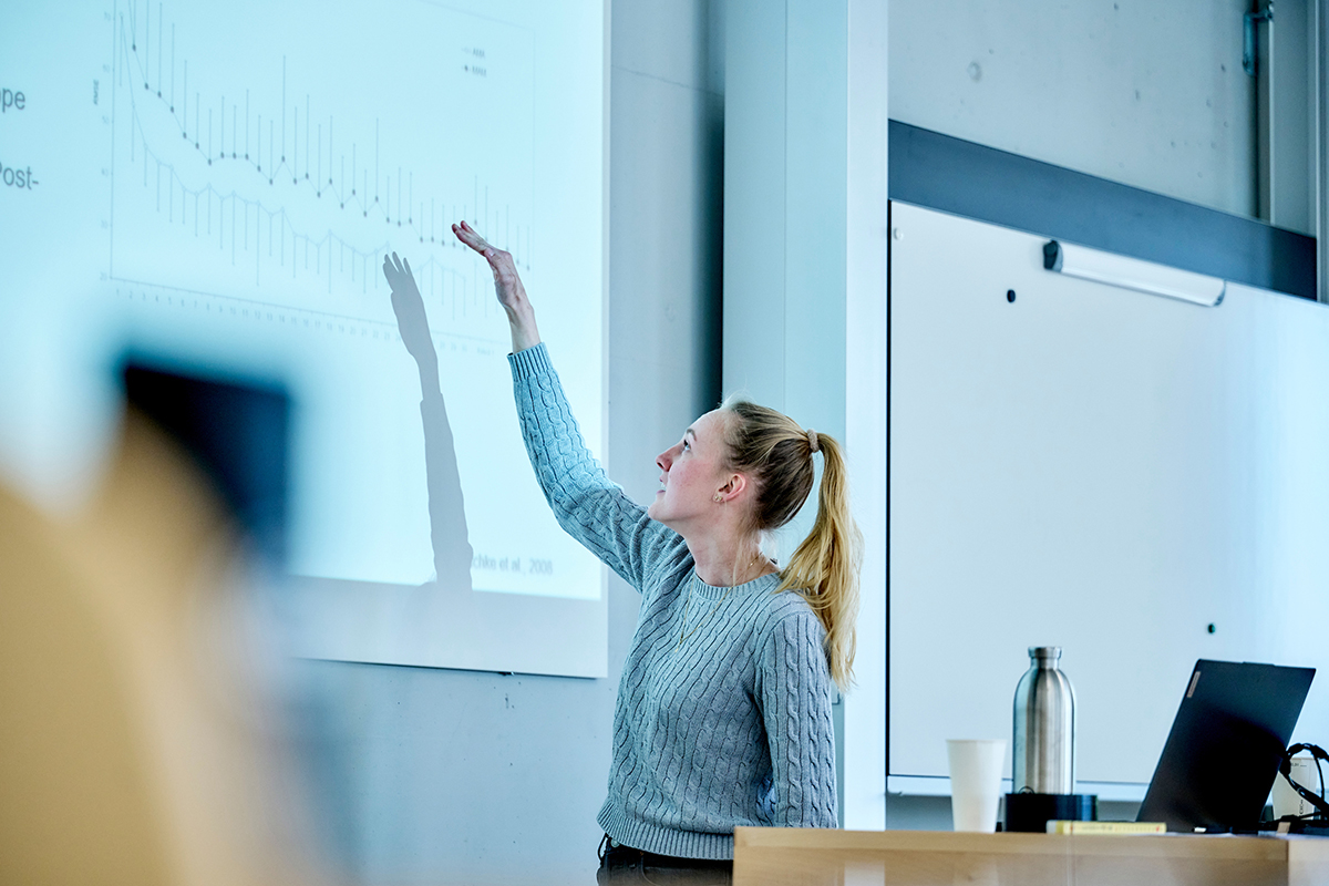 Eine Studentin erklärt eine projezierte Grafik.